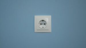 A white electrical outlet on a blue wall