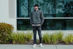 a man standing on a sidewalk in front of a building