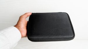 a person holding a black case in their hand