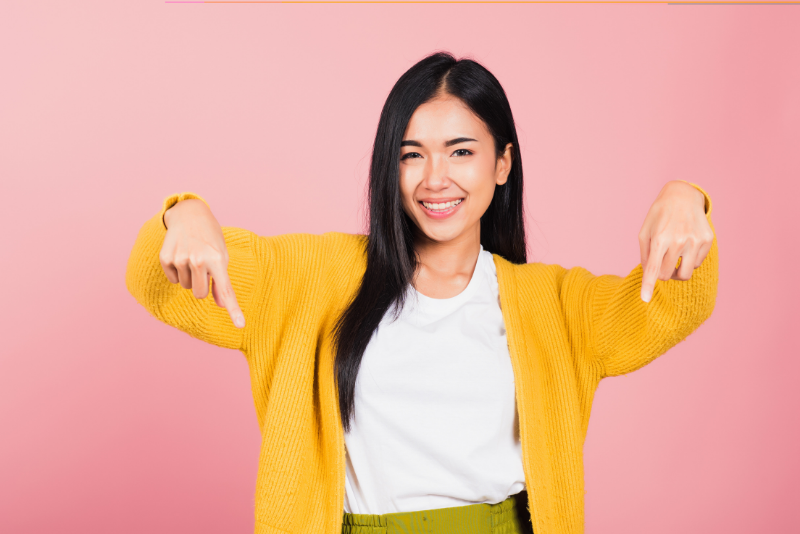Asian woman pointing downward