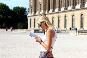woman in white tank top holding white book