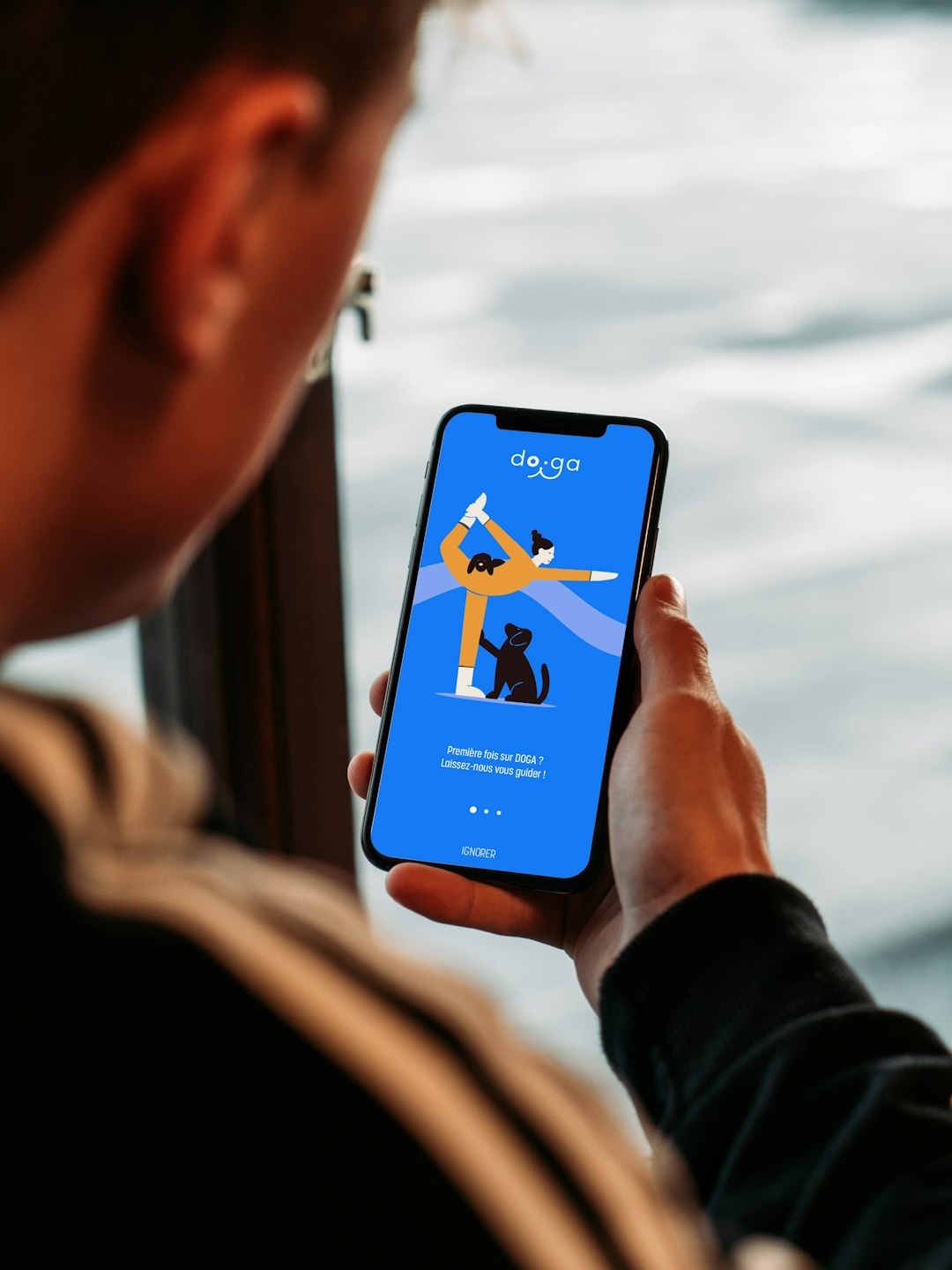 Photo by Lola Waligora-Thomas Person holding a smartphone with a yoga app.